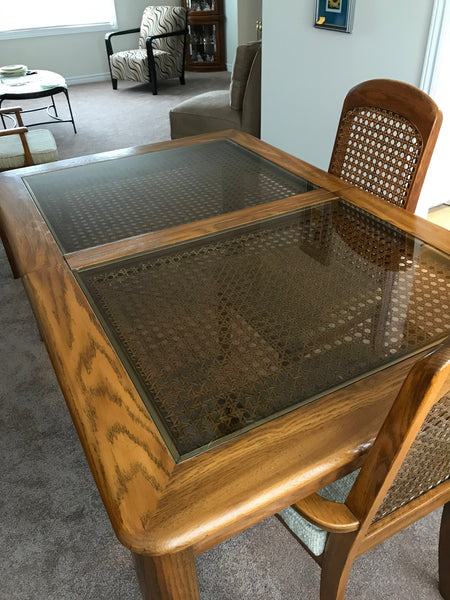 Dining room table, wood finish with glass and woven cane inlay.