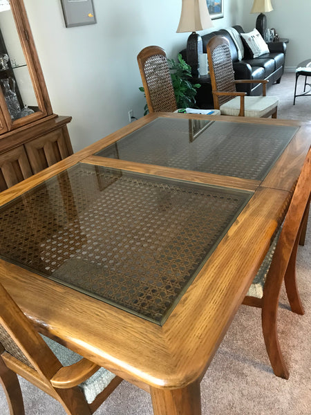 Dining room table, wood finish with glass and woven cane inlay.